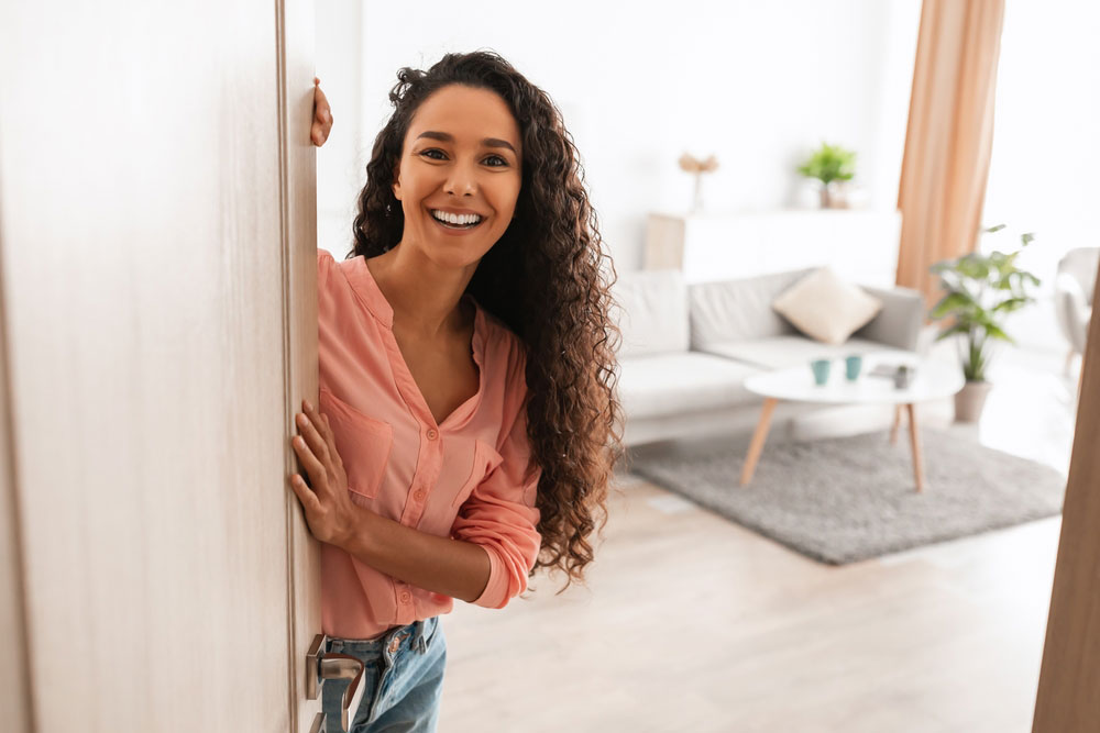pretty lady with curly hair smiling in open doorway