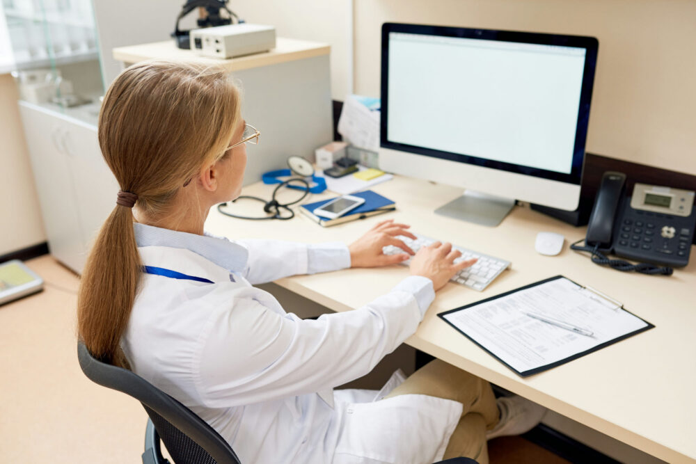Doctor reviewing patient records on a computer for fentanyl detox Georgia outpatient